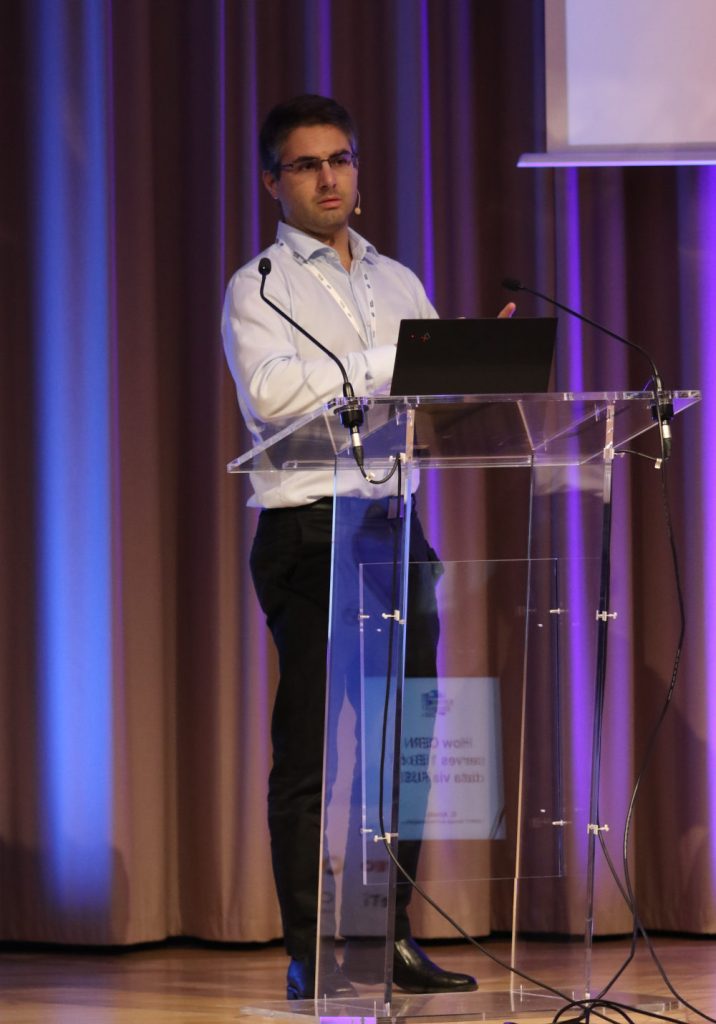 Guilherme Amadio speaking in front of his laptop.